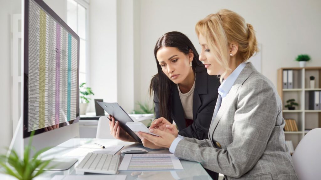 Dwie kobiety analizują plany budowy podczas spotkania 