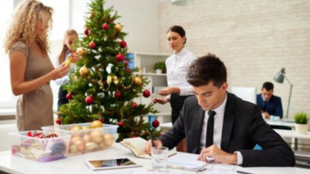 Pracownicy ubierający choinkę w biurze